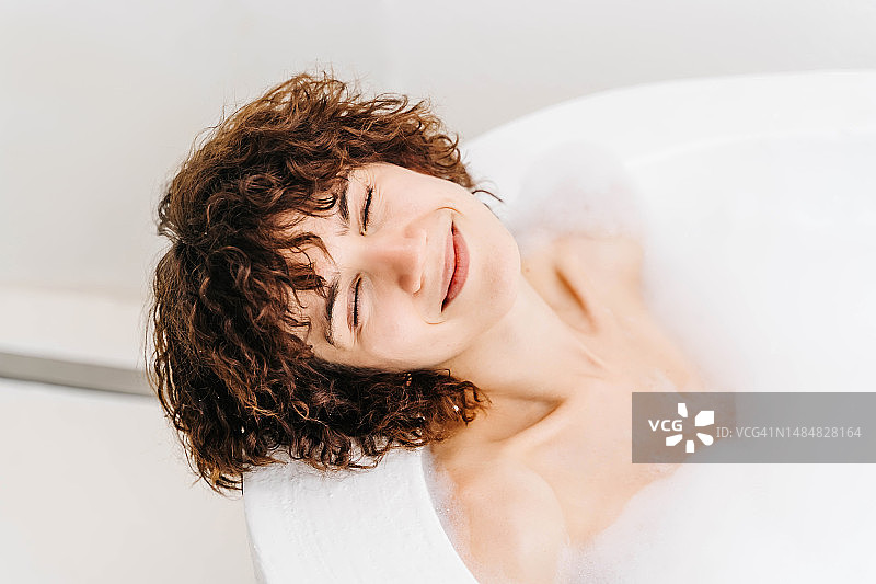 年轻漂亮的短发女子正在泡泡浴，放松身心图片素材