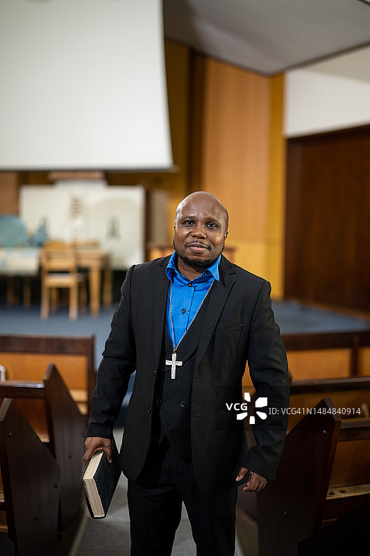 牧师手持圣经站在教堂内的肖像照图片素材