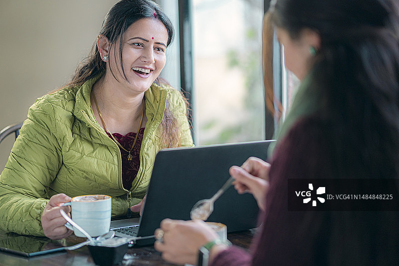 商务女人面对面坐着使用笔记本电脑开会图片素材
