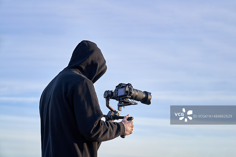 摄影师在海滩上使用稳定器拍摄图片素材