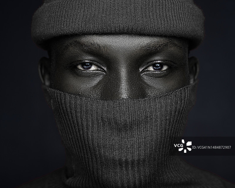 戴面具的男子特写肖像，黑色背景图片素材