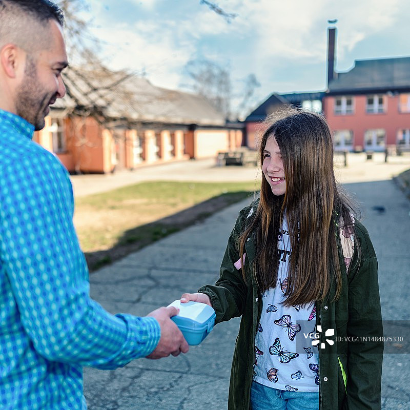 孩子从父亲那里拿午餐盒图片素材