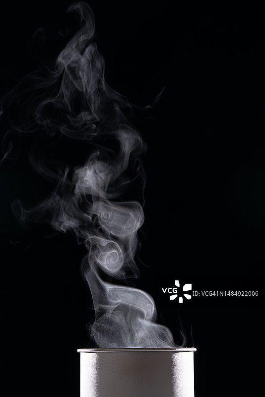 黑色背景上热饮杯中升起的热气图片素材