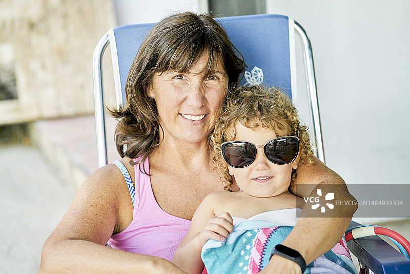 年长的白人妇女和儿子在户外沐浴阳光，面带微笑看向镜头图片素材