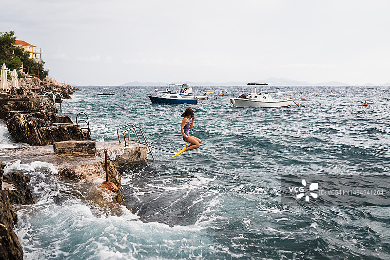 女人从悬崖上跳跃图片素材