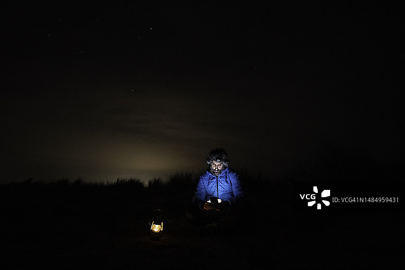 在海边夜晚用手机的男人图片素材
