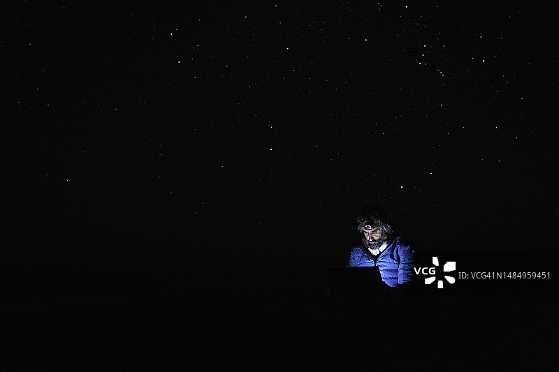 在海边夜晚用笔记本电脑工作的人们图片素材