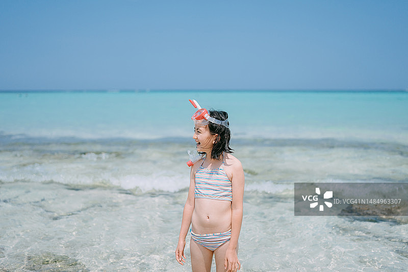 在热带海滩戴着呼吸管的年轻女孩图片素材
