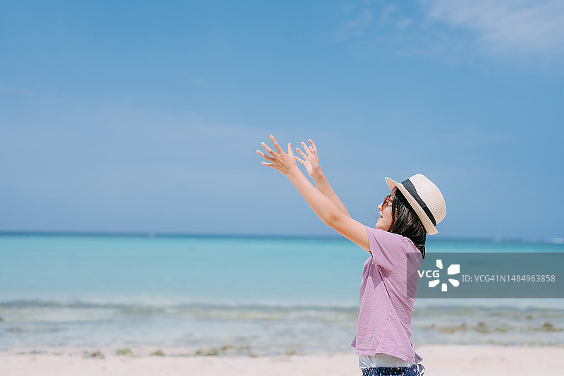 年轻女孩试图在海滩上接球图片素材