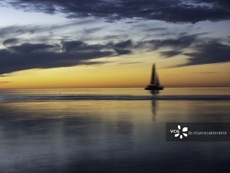 水上柔和的日落与漂浮的船只图片素材