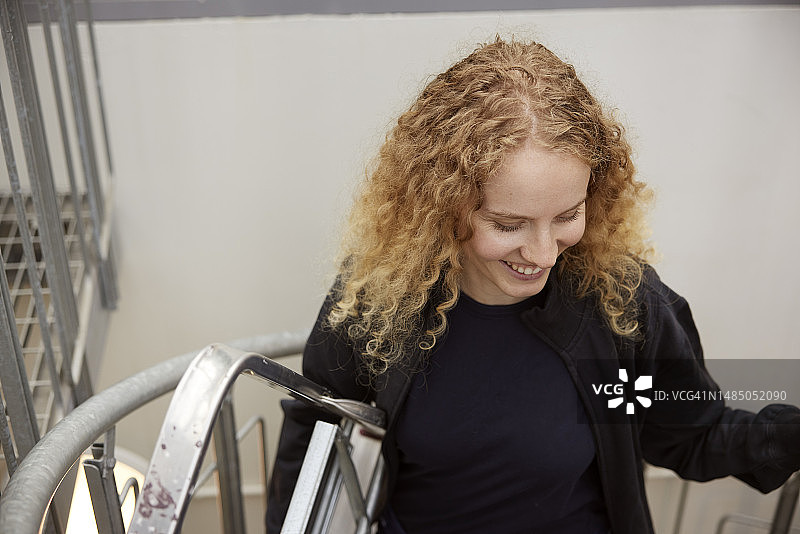 携带梯子的年轻微笑女人图片素材