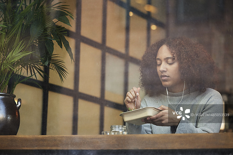 在咖啡馆用餐的年轻女人图片素材