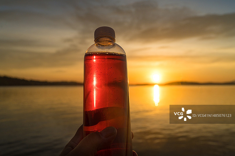 日出时分塑料瓶中的红树莓饮品图片素材