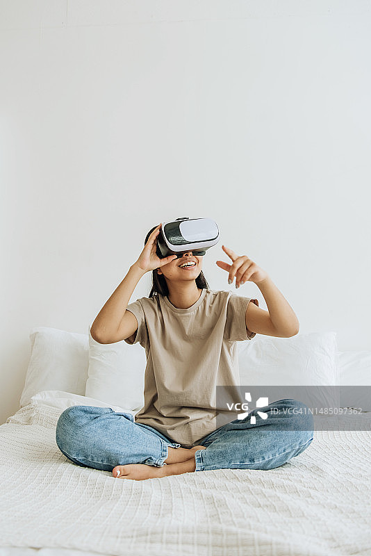 年轻女人在家使用VR眼镜图片素材