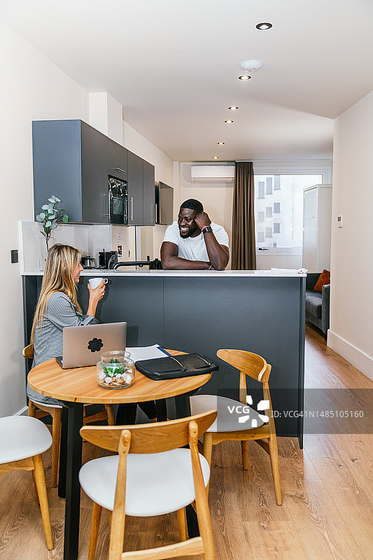 居家办公：时尚金发女郎和英俊黑人男子在现代阁楼公寓中高效工作图片素材