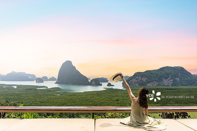 清晨，绿裙女子坐在萨米特南谢观景点欣赏山景图片素材