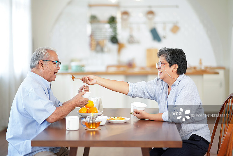 在厨房里吃饭的亚洲老年人图片素材