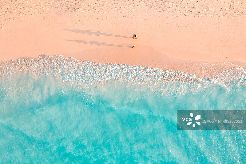 宁静自由的情侣，空中海滩景观。沙滩上柔和的日落光线和阴影，迷人的海洋泻湖海湾。户外活动，休闲，步行乐趣旅行度假合影概念图片素材