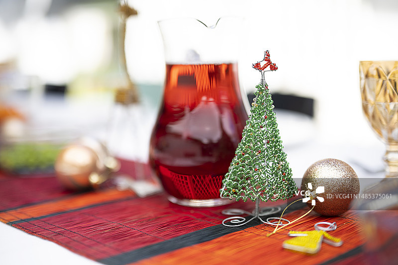 餐桌上带有红色果汁罐的串珠圣诞树装饰品图片素材