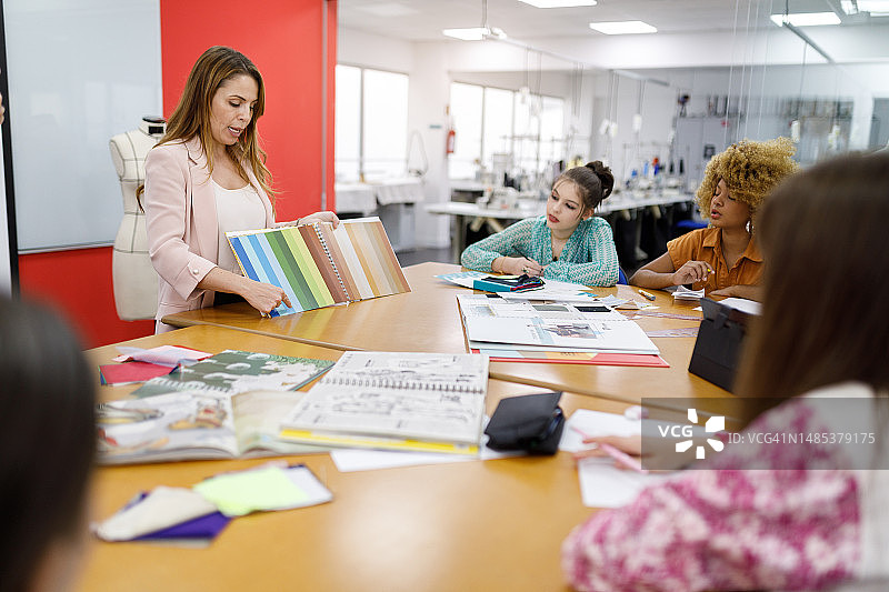 教授向时装专业的学生讲解颜色和面料图片素材