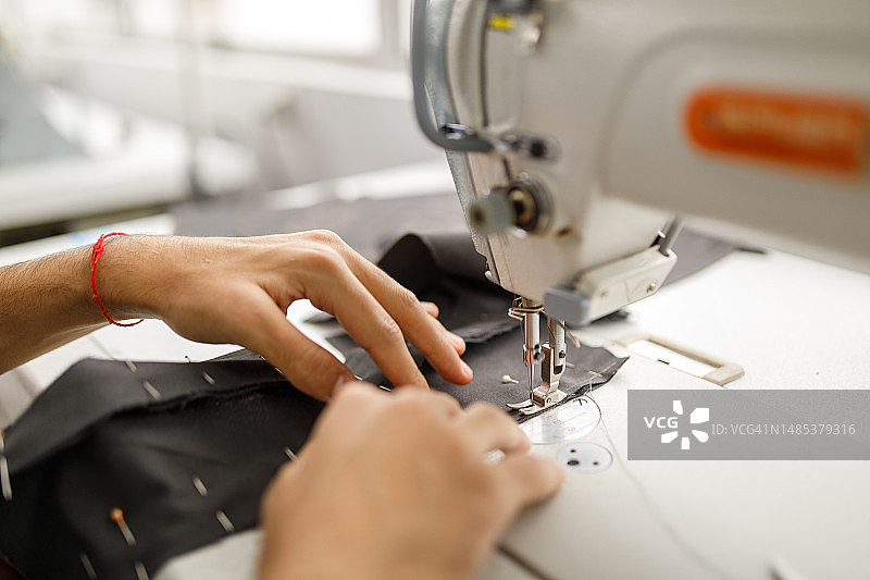 用缝纫机缝制布料的手图片素材