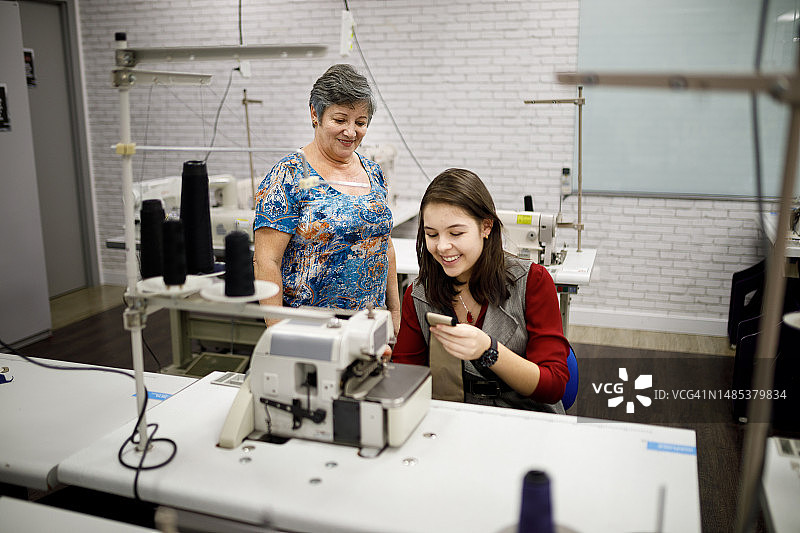 裁缝检查学生操作缝纫机图片素材