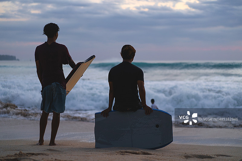 少年日落时分趴板冲浪图片素材