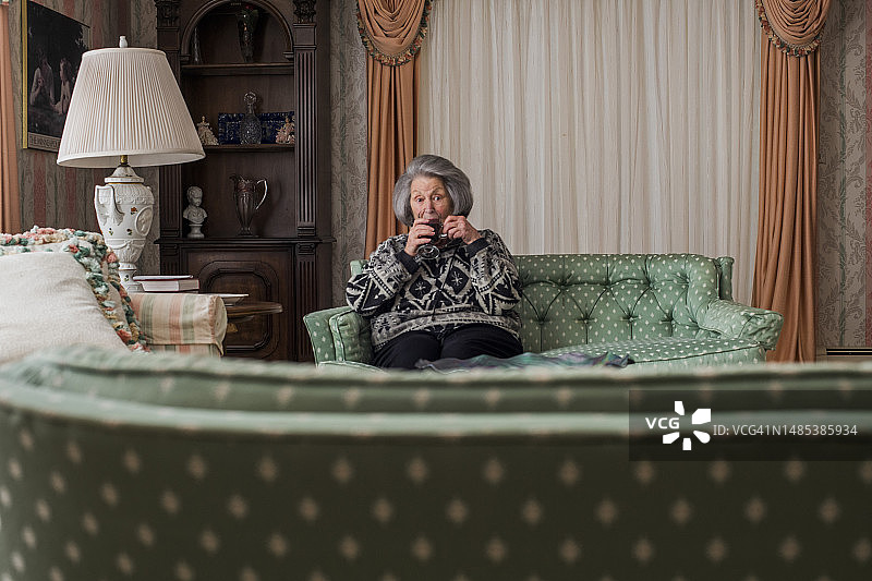 奶奶在舒适的房间里喝咖啡图片素材