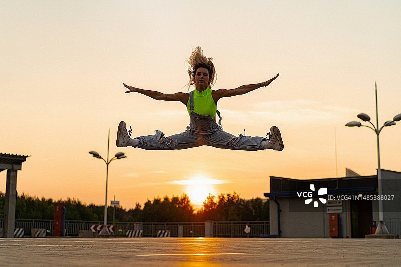 以日落为背景跳跃的女人图片素材