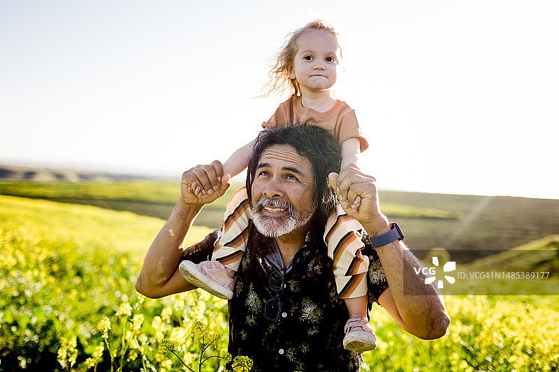 在圣地亚哥花田里坐在叔叔肩膀上的两岁小孩图片素材