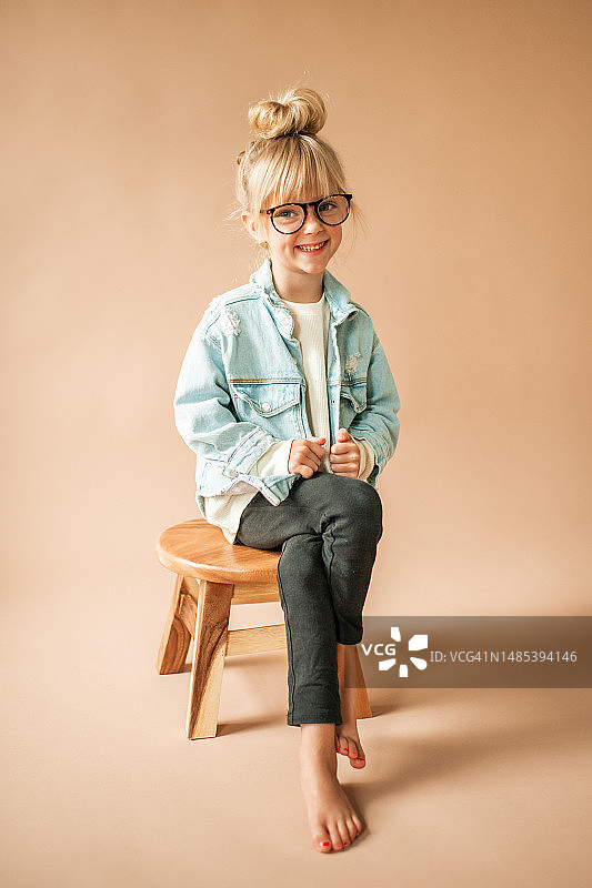 快乐的戴眼镜可爱幼儿女孩的肖像图片素材