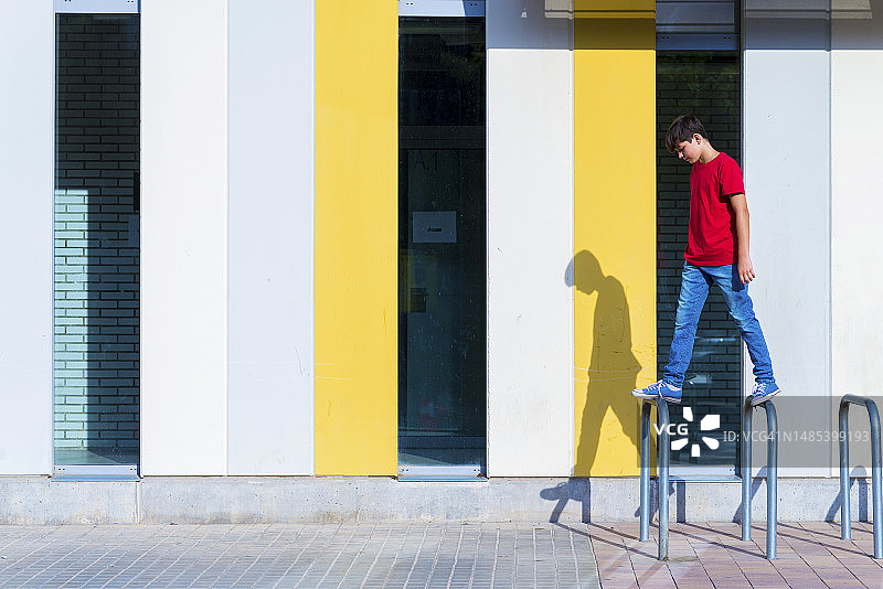 坐在城市自行车上的年轻少女靠墙而立图片素材
