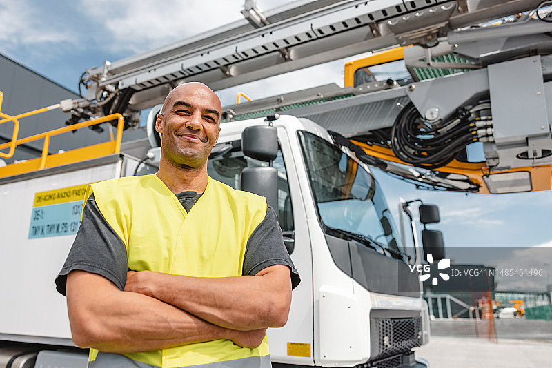 站在除冰车前的微笑拉丁美洲男人图片素材