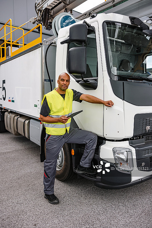 在机场仓库外手持平板电脑的拉丁美洲航空工程师图片素材