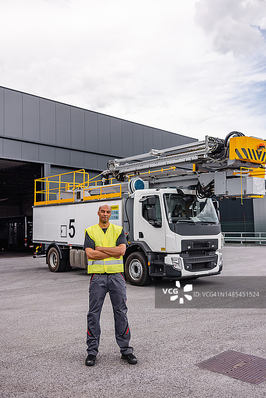 在除冰车前的拉美裔飞机工人图片素材