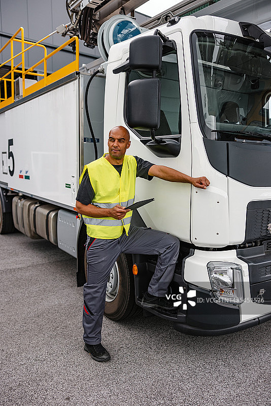 站在除冰车前的穿制服的拉丁美洲男人图片素材
