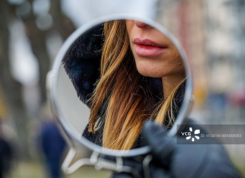 在瑞典户外，女人在镜子前沉思的特写图片素材