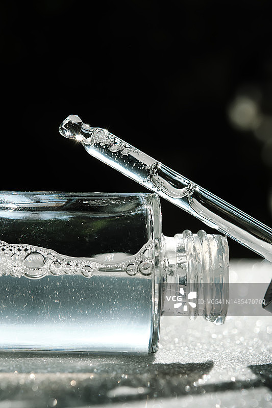 白色背景上带有滴管的精华液瓶图片素材