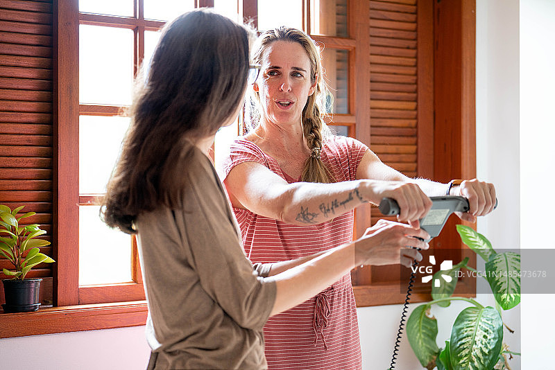 营养师在咨询期间协助客户使用身体成分监测仪图片素材