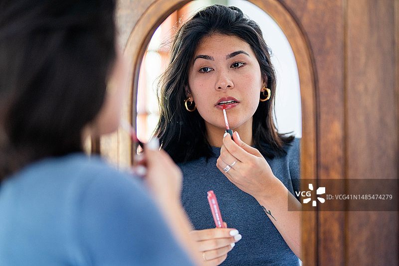 美女在镜子中涂唇彩的倒影图片素材