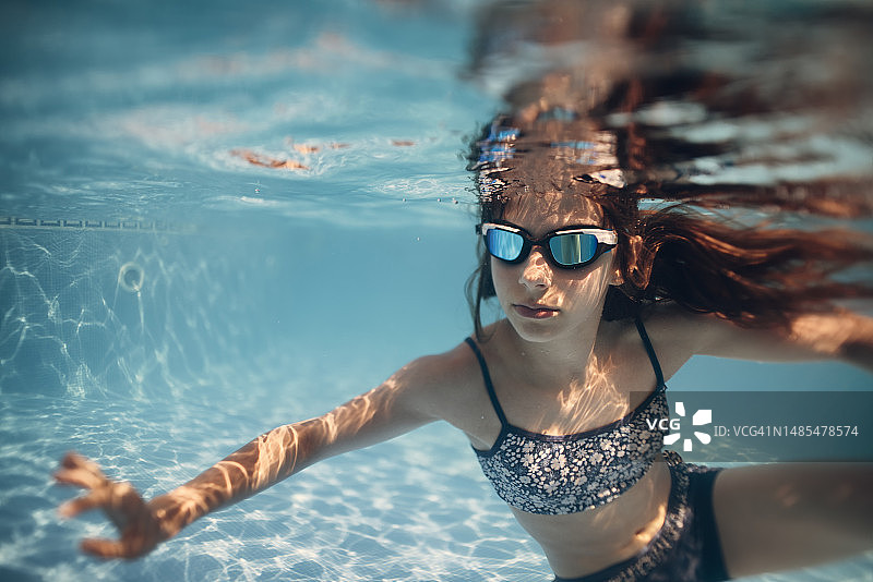 小女孩在游泳池水下游泳图片素材