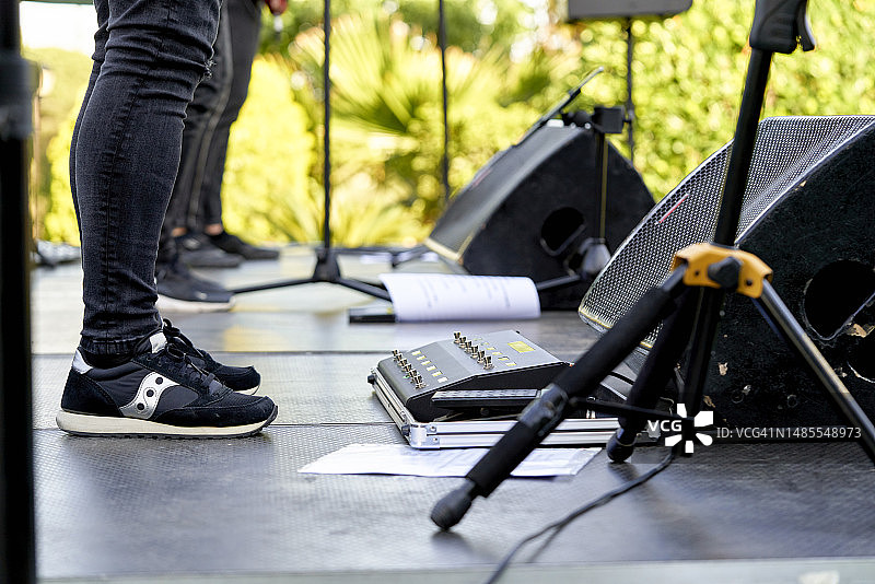 乐队成员站在户外舞台上的中间部分，在观众面前表演前进行练习。图片素材