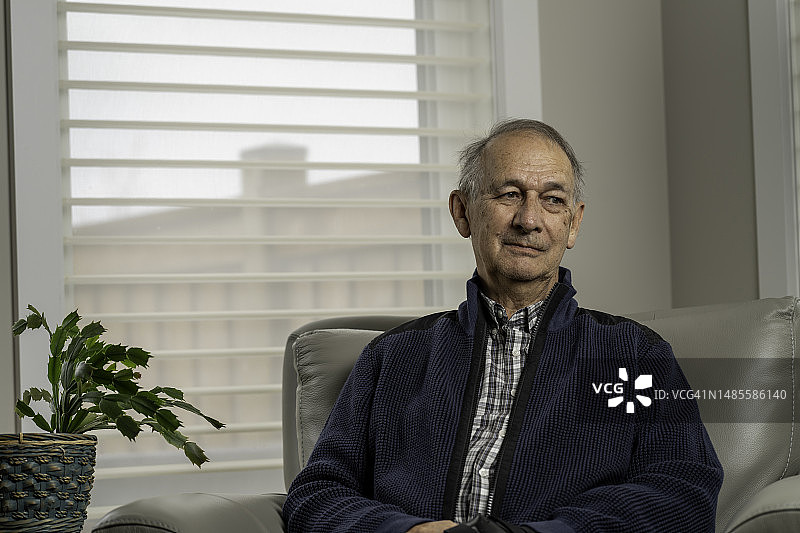 年长的男人坐在客厅的椅子上图片素材