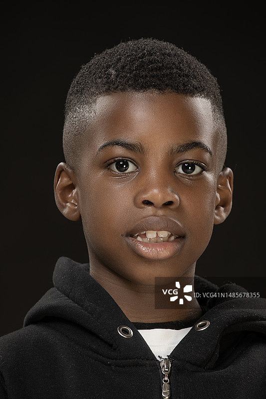 年轻漂亮的黑人男孩摆姿势拍摄工作室肖像。图片素材