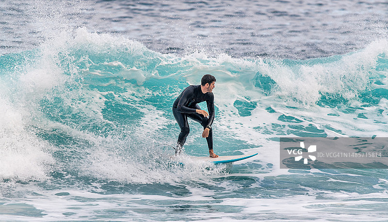 年轻男子在特内里费岛穿着潜水服冲浪图片素材