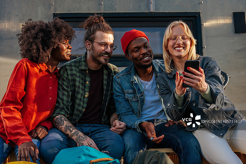 使用手机并在户外社交的快乐朋友图片素材