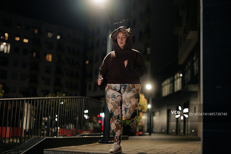 夜晚在户外慢跑的白人女性图片素材