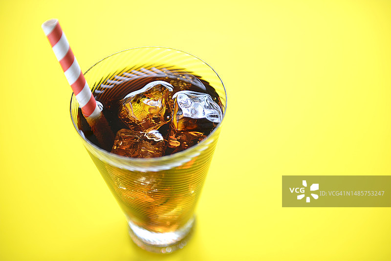 黄色背景上的可乐和吸管图片素材