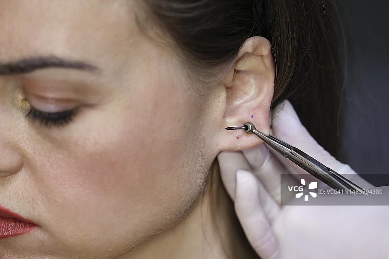 年轻女人穿耳洞图片素材