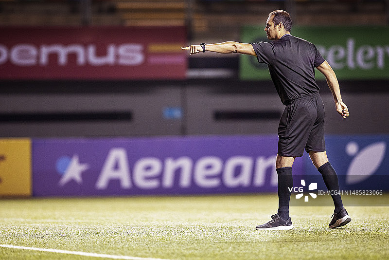 沮丧的裁判在国际足球比赛中示意球员后退图片素材